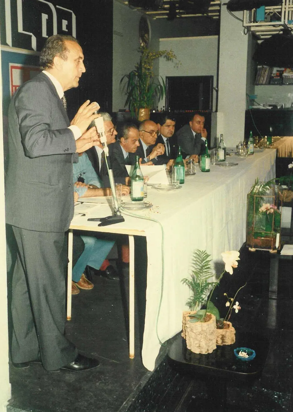 In piedi al microfono durante un convegno